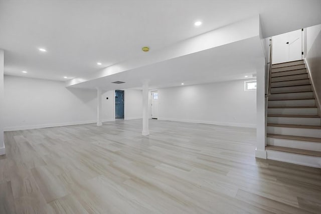 basement with light hardwood / wood-style flooring