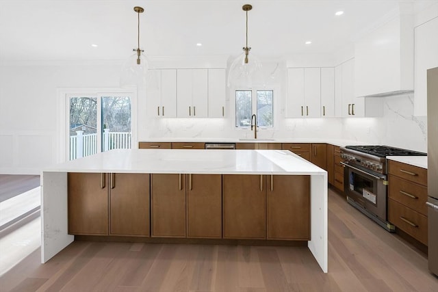 kitchen featuring white cabinets, decorative light fixtures, sink, and stainless steel stove