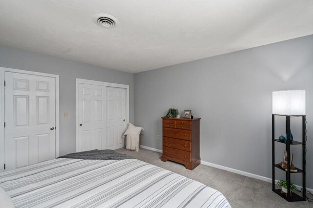 bedroom featuring baseboards, carpet, a closet, and visible vents