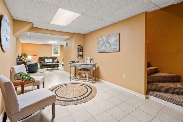 sitting room featuring light tile patterned floors, baseboards, and a paneled ceiling