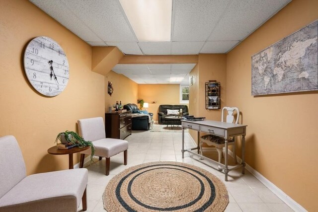 office featuring baseboards, a drop ceiling, and light tile patterned floors