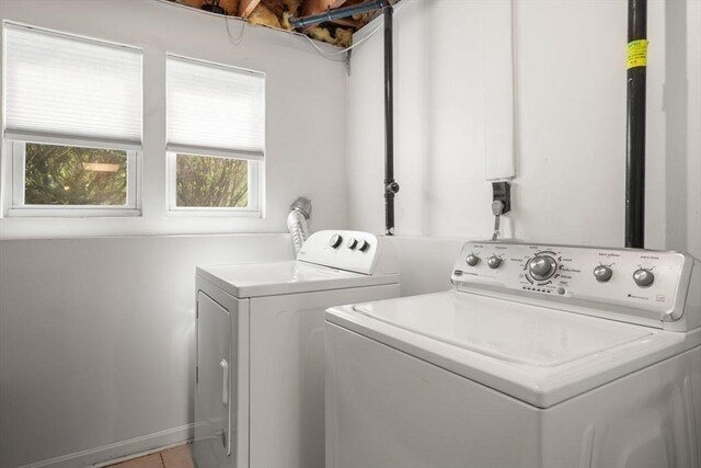clothes washing area featuring laundry area, light tile patterned floors, and washer and dryer