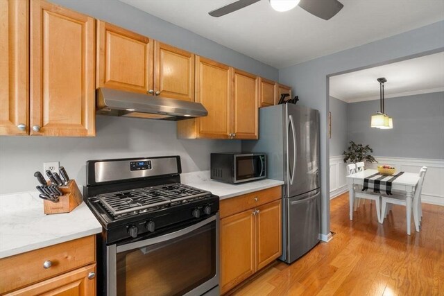 kitchen featuring light wood-type flooring, light countertops, under cabinet range hood, a ceiling fan, and appliances with stainless steel finishes