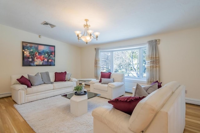 living room featuring baseboard heating, lofted ceiling, light hardwood / wood-style flooring, and a notable chandelier