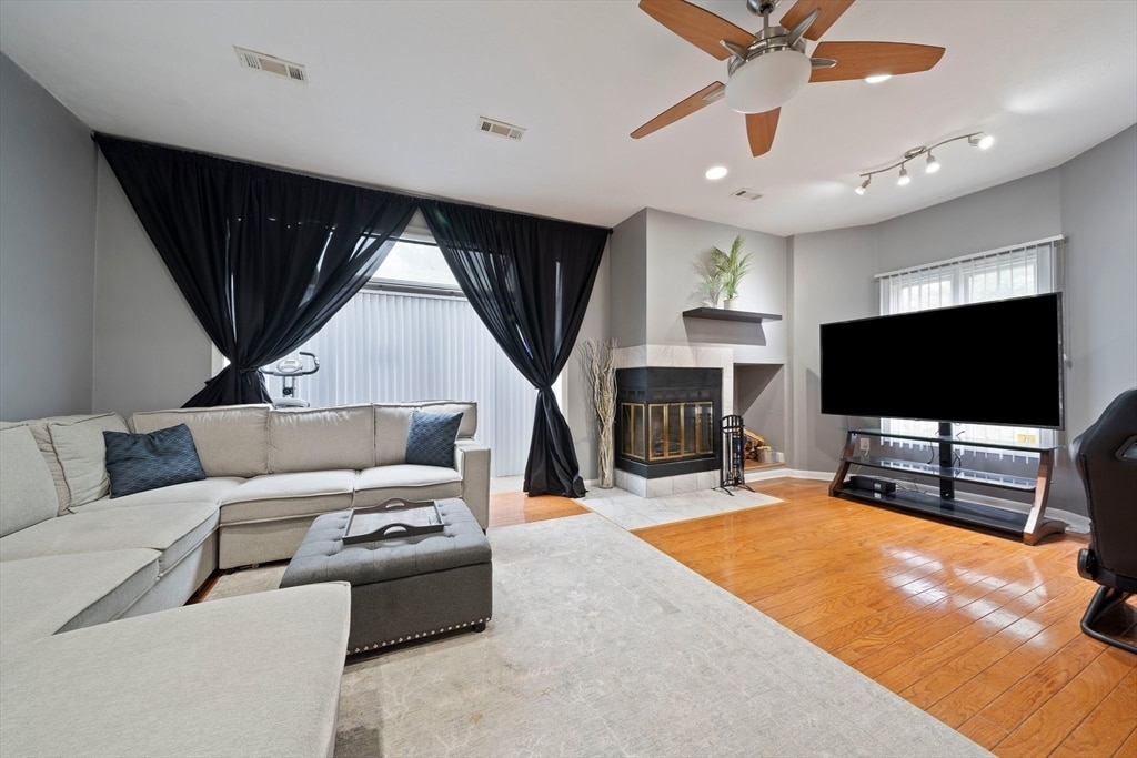 living room with plenty of natural light, light wood-type flooring, and ceiling fan