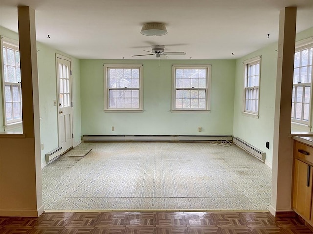 spare room with dark tile patterned flooring, ceiling fan, and a baseboard heating unit