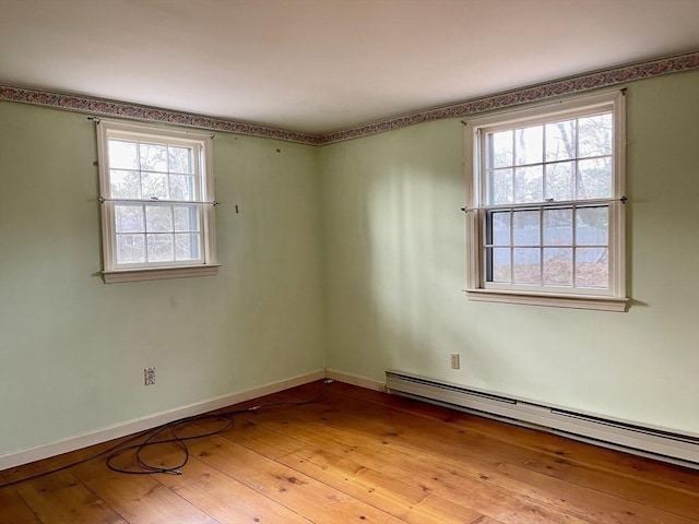 spare room featuring a wealth of natural light, light hardwood / wood-style flooring, and baseboard heating