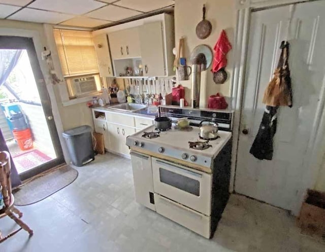 kitchen featuring sink, a paneled ceiling, cooling unit, white cabinets, and white range with gas cooktop