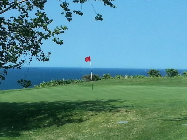 view of property's community with a water view and a yard