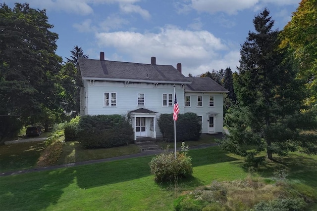 back of house with a lawn