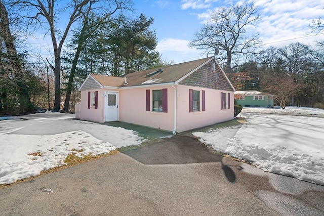 view of property exterior with aphalt driveway and stucco siding