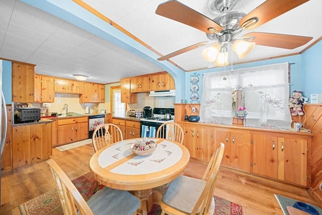 dining area with arched walkways, a toaster, crown molding, and light wood finished floors