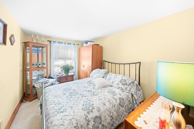 bedroom featuring light carpet and baseboards