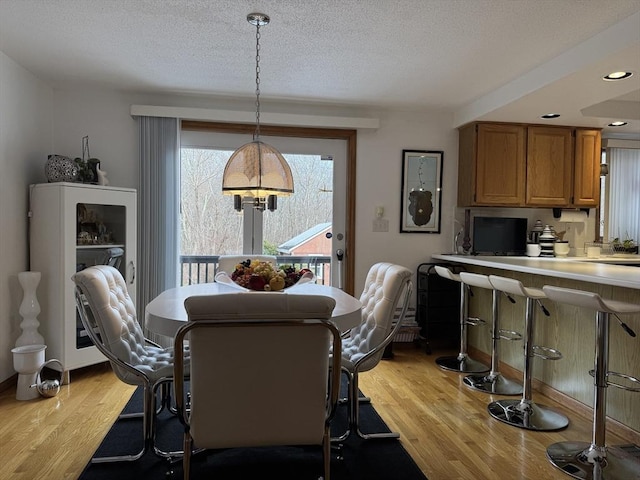 dining room with light hardwood / wood-style flooring and a textured ceiling