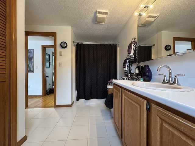 bathroom featuring a textured ceiling, vanity, and tile patterned flooring