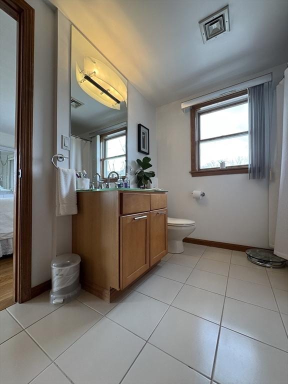 bathroom with toilet, tile patterned floors, and vanity