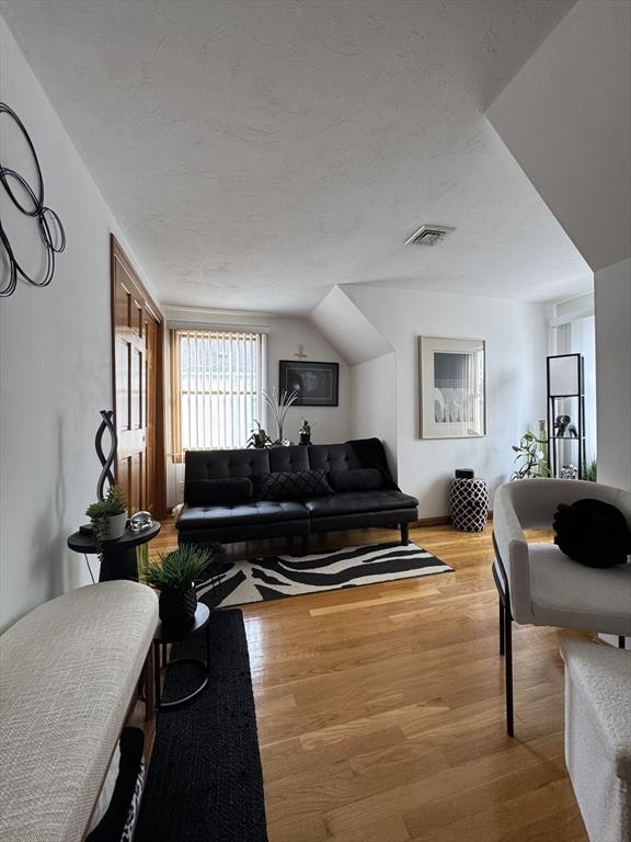 living room with vaulted ceiling and hardwood / wood-style floors