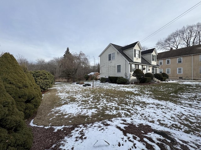 snow covered property with covered porch