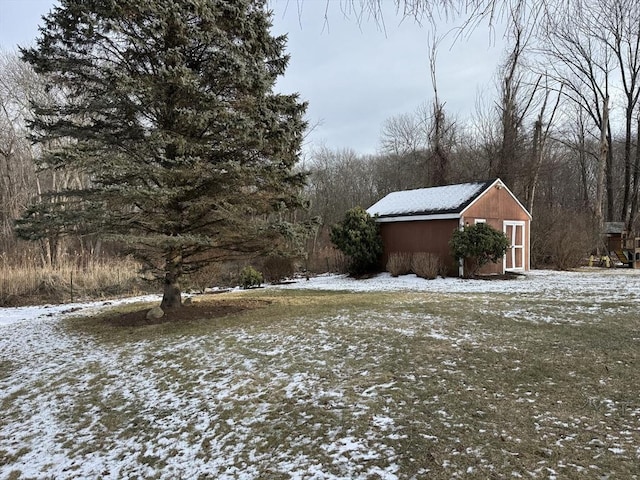 yard layered in snow with a shed