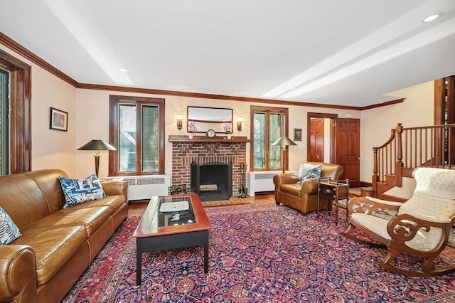 living room with crown molding, plenty of natural light, radiator heating unit, and stairs