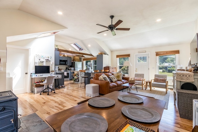 living room featuring light hardwood / wood-style flooring, ceiling fan, and vaulted ceiling