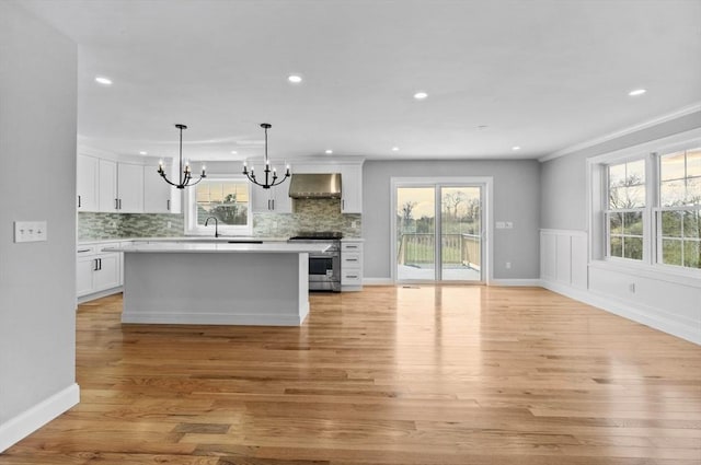312 Old Westport, Dartmouth, MA 02747 - kitchen with stainless steel electric range, range hood, a chandelier, a sink, and light wood-style flooring
