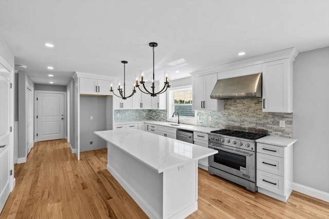 312 Old Westport, Dartmouth, MA 02747 - kitchen featuring wall chimney exhaust hood, appliances with stainless steel finishes, a chandelier, a sink, and white cabinets