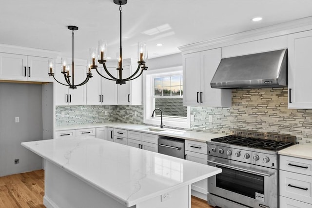 312 Old Westport, Dartmouth, MA 02747 - kitchen featuring wall chimney range hood, stainless steel appliances, a chandelier, a sink, and decorative backsplash