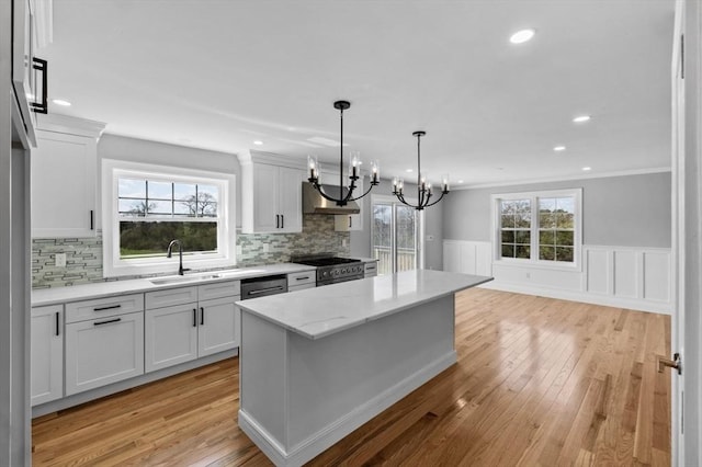 312 Old Westport, Dartmouth, MA 02747 - kitchen with high end stainless steel range, a sink, a chandelier, light wood-style floors, and wall chimney exhaust hood