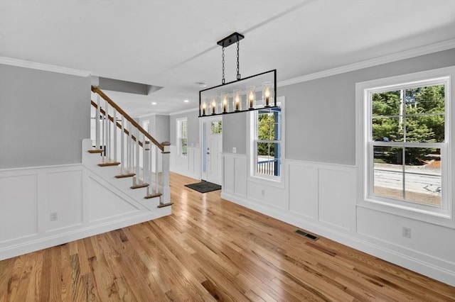 312 Old Westport, Dartmouth, MA 02747 - unfurnished dining area featuring a decorative wall, stairs, light wood finished floors, crown molding, and wainscoting
