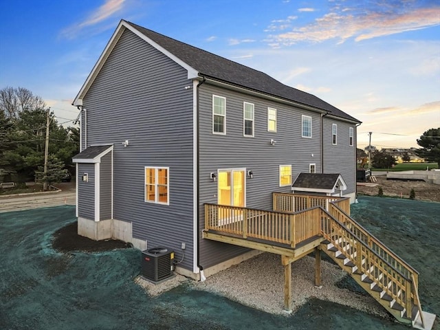 312 Old Westport, Dartmouth, MA 02747 - back of house at dusk featuring central AC unit, a wooden deck, and stairs