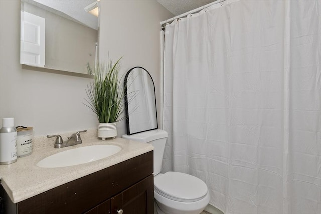 bathroom featuring vanity, toilet, and a textured ceiling