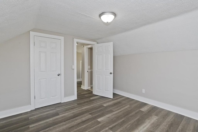 bonus room featuring a textured ceiling, dark hardwood / wood-style flooring, and vaulted ceiling