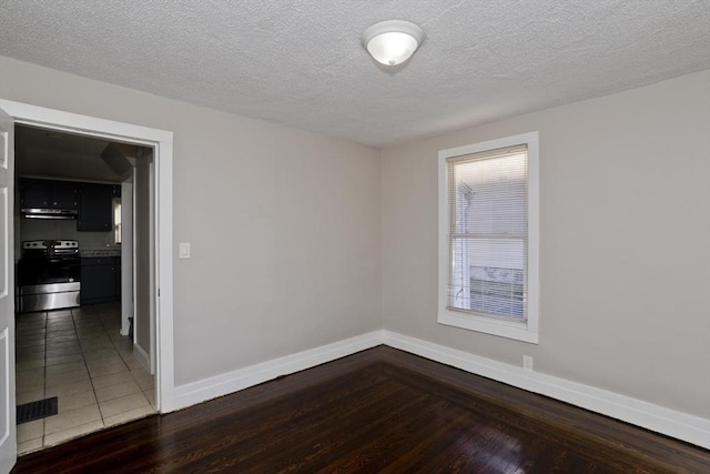 unfurnished room featuring a textured ceiling and dark hardwood / wood-style floors