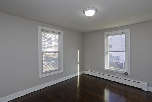 unfurnished room featuring dark hardwood / wood-style flooring and baseboard heating