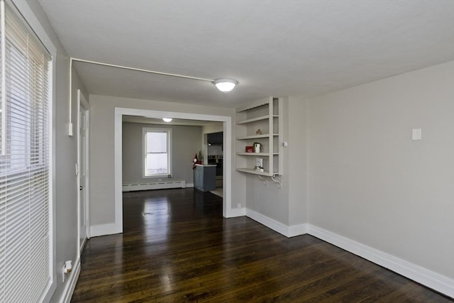 empty room featuring a baseboard radiator and dark wood-type flooring