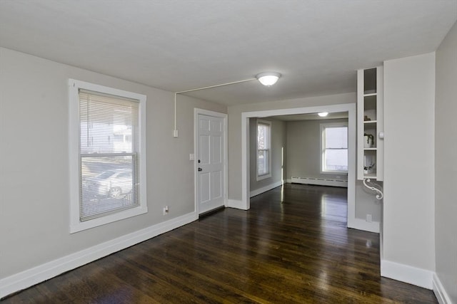 foyer entrance with dark hardwood / wood-style floors and baseboard heating