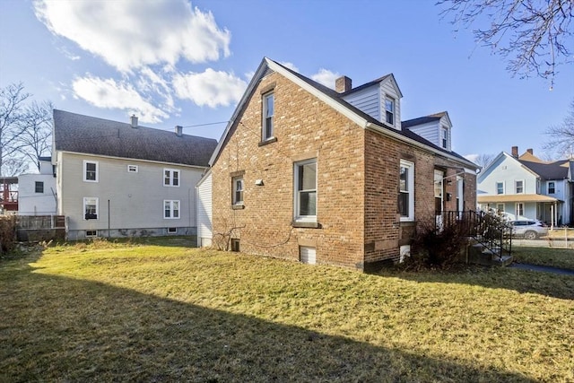 rear view of house with central air condition unit and a lawn