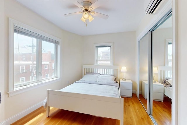10 Bradbury St Unit 10, Boston, MA 02134 - bedroom featuring a wall unit AC, multiple windows, light wood-type flooring, and a closet