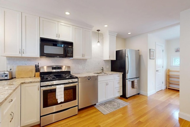 10 Bradbury St Unit 10, Boston, MA 02134 - kitchen featuring stainless steel appliances, tasteful backsplash, white cabinetry, light wood finished floors, and a sink