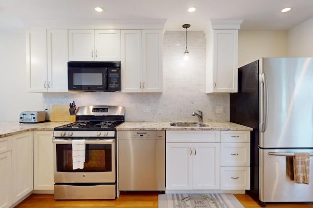 10 Bradbury St Unit 10, Boston, MA 02134 - kitchen with stainless steel appliances, a sink, white cabinets, light stone countertops, and tasteful backsplash