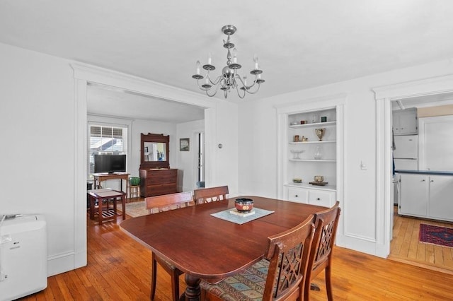 52 Locust St, Lynn, MA 01904 - dining area with light wood-type flooring, built in shelves, and an inviting chandelier