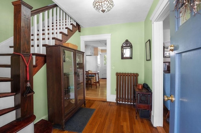 52 Locust St, Lynn, MA 01904 - foyer entrance with radiator heating unit, baseboards, stairs, and wood finished floors