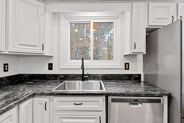 kitchen with appliances with stainless steel finishes, sink, and white cabinets