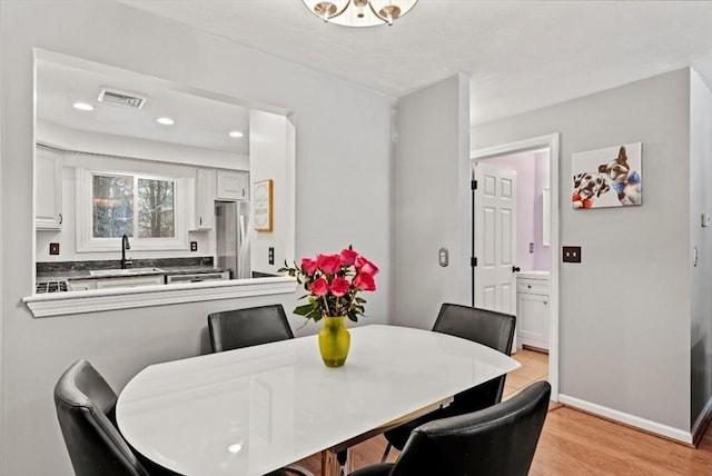 dining room featuring sink and light hardwood / wood-style floors