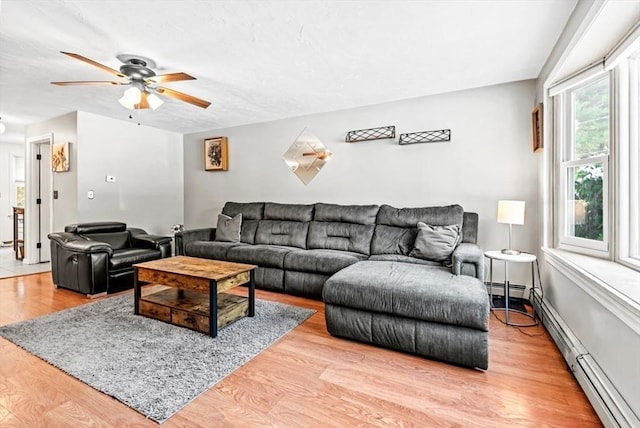 living room featuring ceiling fan, baseboard heating, and light hardwood / wood-style flooring