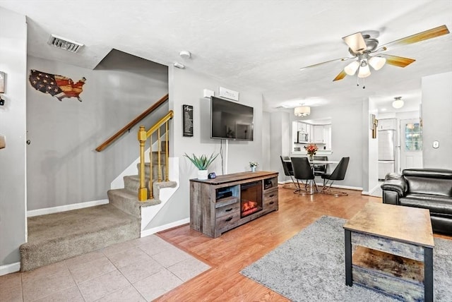 living room with light hardwood / wood-style flooring and ceiling fan