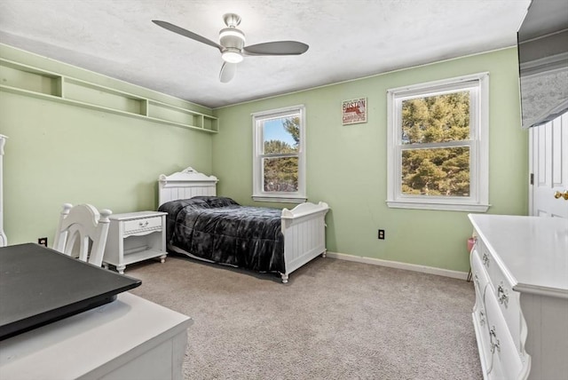 bedroom with ceiling fan, light colored carpet, and multiple windows