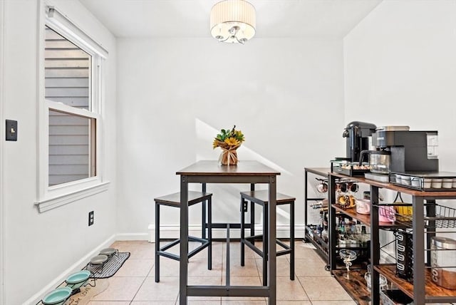 tiled dining space featuring a baseboard heating unit