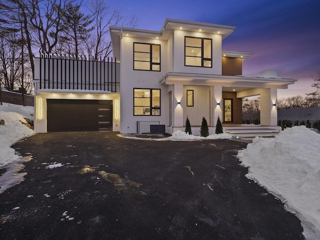 view of front of house featuring a garage, driveway, a porch, and stucco siding